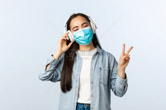 女青年疫情期间戴着口罩戴着耳机在听歌图片