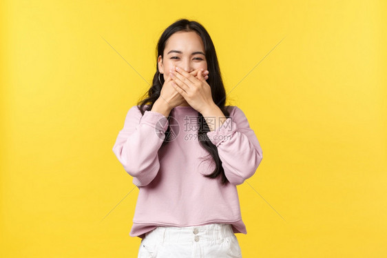 有趣的韩国女孩笑用手掌遮住嘴唇图片