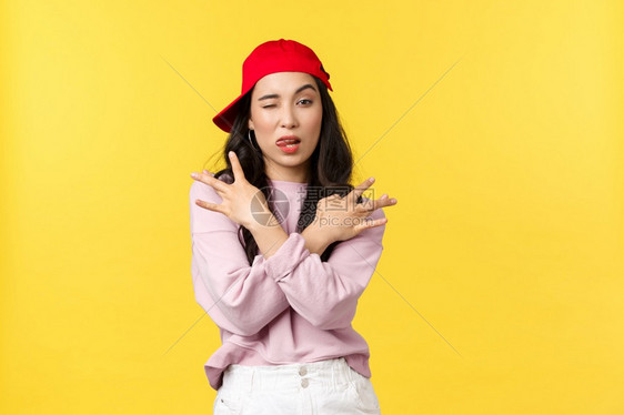 人们的情绪生活方式闲暇和美观概念冷酷和迷人的时髦女孩穿着红色的hipo帽子展示着高雅的手势和笑容满怀信心地站在黄色背景之上人们的图片