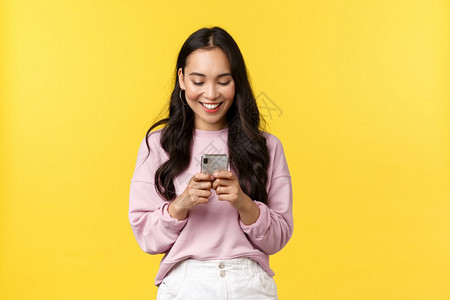 年轻现代亚洲女孩博客在社交媒体上发表文章使用智能手机短信微笑地看待手机人们的情感生活方式闲暇和美丽概念年轻现代亚洲女孩博客在社交图片