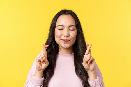 人们的情感生活方式闲暇和美丽概念梦幻和充满希望的亚洲女孩用闭着的眼睛和快乐微笑许愿黄色的背景休闲和美丽概念梦幻和充满希望的亚洲女图片