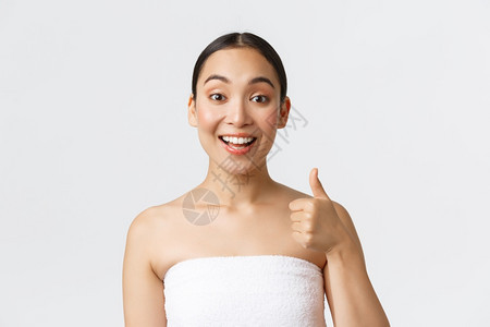 美容和温泉沙龙概念满足快乐的像亚洲女客户在白毛巾上展示拇指和笑的喜悦推荐美容保证质量美容和温泉沙龙概念满足快乐的像亚洲女客户在白图片
