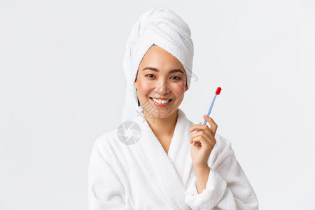 穿着浴袍和毛巾洗发用牙刷站立白背景个人护理妇女美貌洗澡和淋浴概念用牙刷洗澡和淋浴概念图片