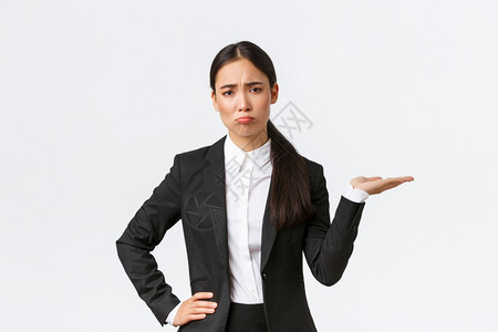 失望和沮丧的女销售经理人身穿黑西装的房地产经纪人工作糟糕的一天粗鲁和看起来很沮丧展示一些东西握着右手白色背景失望和沮丧的女销售经图片