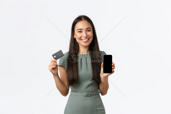 展示移动屏幕应用程序和信卡引入银行应用程序白背景小企业主女家概念微笑展示移动屏幕应用程序和信卡图片