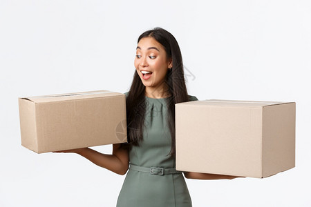 小商业主创办人和在家工作的概念令人惊讶的是像一个女人带着两箱的订单看着快乐和高兴从后办公室收集包裹小商业主开办人和在家工作的概念图片