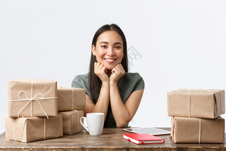 利用数字平板销售产品在线商店包装船订单的箱小企业所有者开办和电子商务概念包装船订单的箱等在家里工作的成功女商人图片