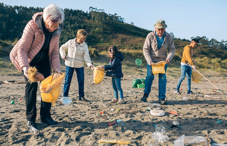 一群志愿者在海滩上捡垃圾图片