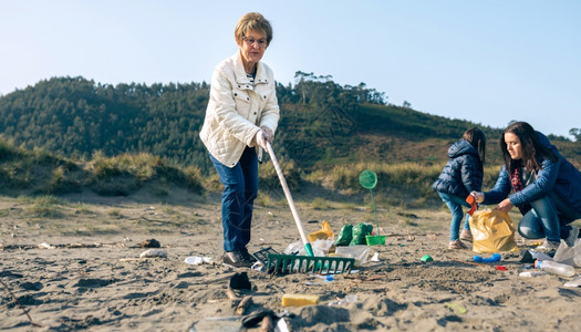 女志愿者在海滩上打扫女志愿者在海滩打扫图片