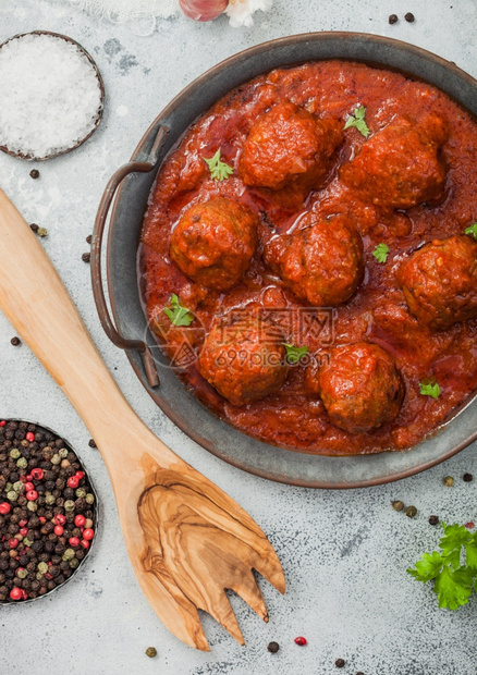 番茄酱中的肉丸子辣椒大蒜和面食用具的浅桌图片