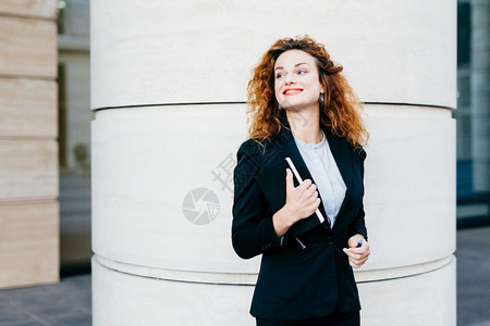 穿着白上衣黑外套和裙子的女商人看起来优雅图片