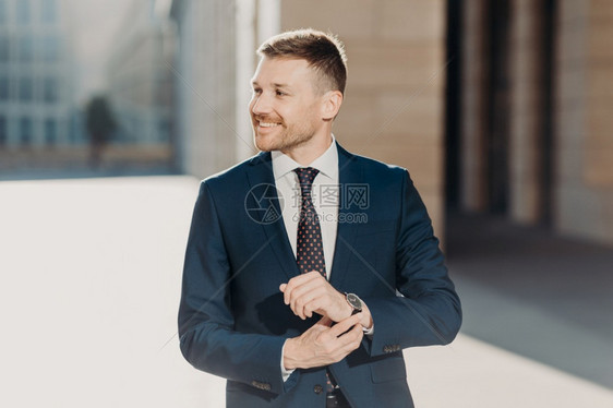 快乐的男ceo穿着优雅的正规西装站在户外的街道上有温柔的积极笑容欢欣其职业生涯的成功青年商人完成业项目的工作图片