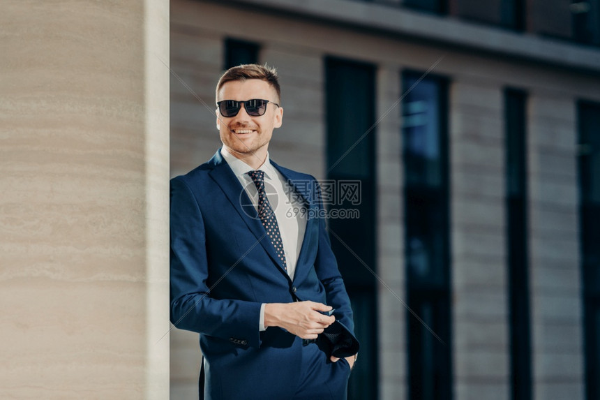 自信的男经理人穿着白色衬衫黑西装和领带手持口袋看起来很亲近对出国差感到满意在办公室内部担任职务图片