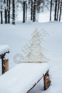 长椅上白人造壁木的垂直镜头上面有雪冬季冻森林节日装饰季概念假期冬季快乐图片