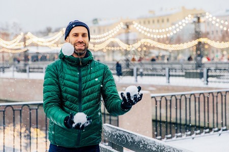 笑的男人把雪球扔在空气中图片