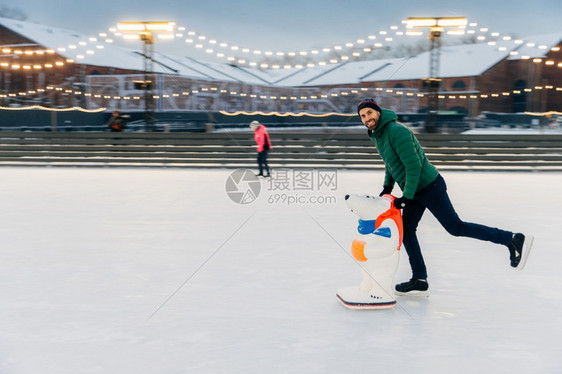 快乐的中年男子滑冰者肖像站在环上享受自由时间有积极的生活方式在冰竞技场上笑的欢男子乐冬季天气滑冰援助爱好概念图片