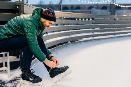 快乐的男鞋带滑冰在环上练习心情好像冬天一样和最好的朋友滑冰图片