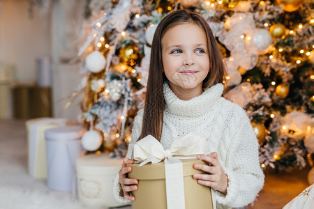 可爱的小孩外貌迷人乐于收留圣诞礼物带着快乐的表情抛开一旁图片
