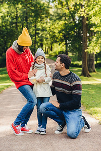 可爱的小孩子很高兴得到父母的支持分享她情感之后参观的温馨装饰在公园里放松的很好模范家庭在公园里散步快乐的表达方式图片