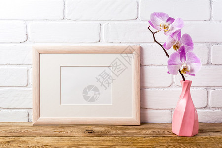 在扭曲的花瓶中用粉红色兰花制成的木质模型空框拟演示设计现代艺术的模板框架图片
