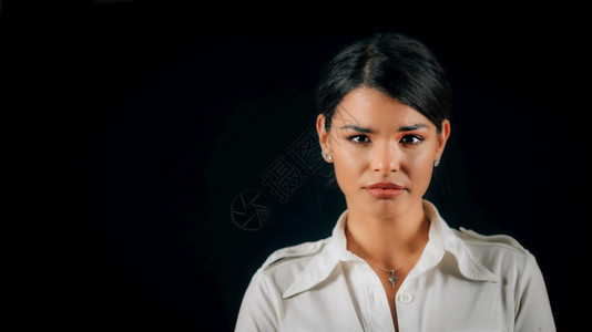 一位美丽悲伤的年轻女子面容表达悲伤工作室肖像黑色背景图片