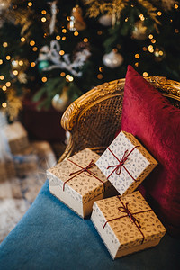 新年树附近舒适的扶手椅上装饰包礼物盒由无法辨认的人准备圣诞礼物美丽的节日装饰室庆祝概念图片