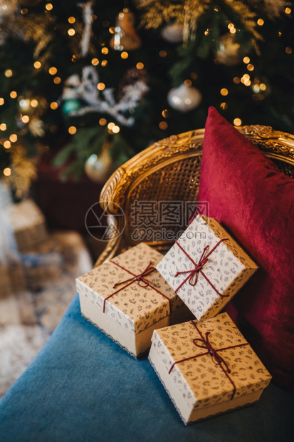 新年树附近舒适的扶手椅上装饰包礼物盒由无法辨认的人准备圣诞礼物美丽的节日装饰室庆祝概念图片