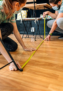 测量地板上社会距离的咖啡店工人测量地板上社会距离的工人图片