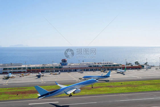 蓝色飞机在马吉拉国际机场跑道起飞图片