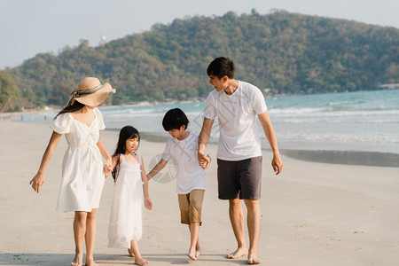 妈妈孩子读书父亲妈和孩子在日落时一起海边散步旅行度假生活方式旅行假期暑概念背景