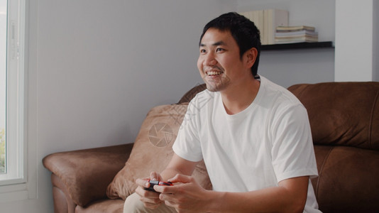 男人在家里的沙发上玩游戏男人在家里玩游戏图片