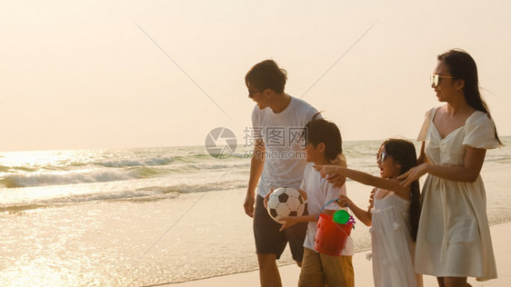 父亲妈和孩子在日落时一起海边散步旅行度假生活方式旅行假期暑概念图片