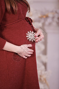 靠近圣诞树的孕妇肚子图片