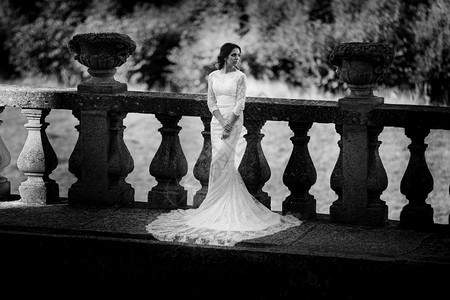 身着豪华礼服的美丽新娘站在大阳台上黑白照片图片