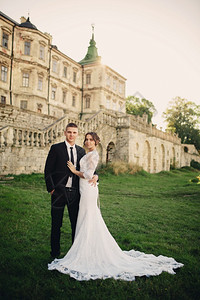 美丽的一对新婚夫妇在旧城堡的背景上相爱图片