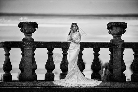 身着豪华礼服的新娘站在大阳台上的黑白照片图片
