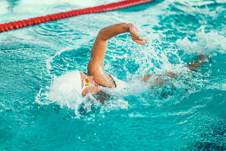 参加游泳池训练的女游泳者前爪风格图片