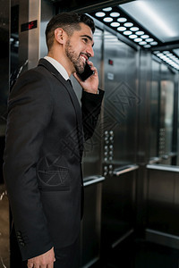 年轻商人在酒店电梯话交谈的肖像商业旅行概念图片