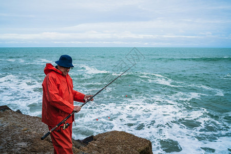 一个老人在海上钓鱼的肖像概念图片