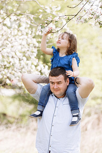 父亲和小孩在果园花户外玩得开心在夏季公园玩耍父亲和他的孩子一起笑享受自然快乐的年轻父亲和他小女儿一起快乐父亲和小孩一起在果园花户图片