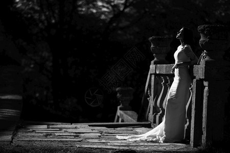 身着豪华礼服的新娘站在大阳台上的黑白照片图片
