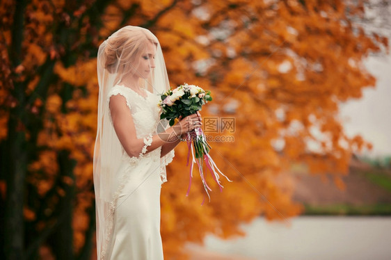 美丽的微笑新娘肖像美丽的新娘肖像闻着婚礼花束的美新娘紧贴着微笑的新娘图片