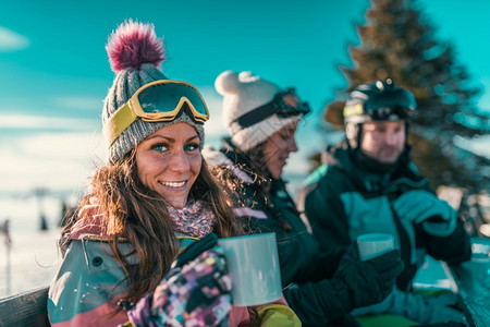 朋友们在山上享受冬日在户外喝咖啡或茶图片