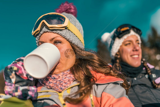 朋友们在山上享受冬日在户外喝咖啡或茶图片