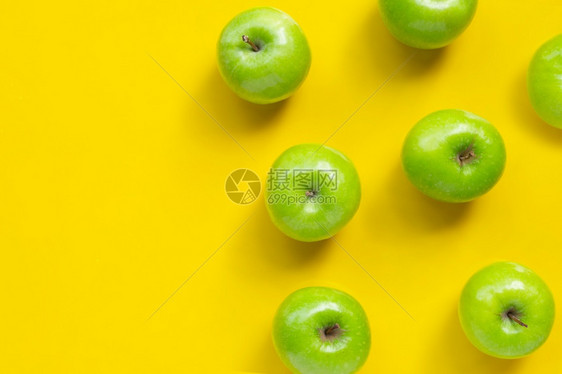 黄色背景上的绿苹果复制空间图片