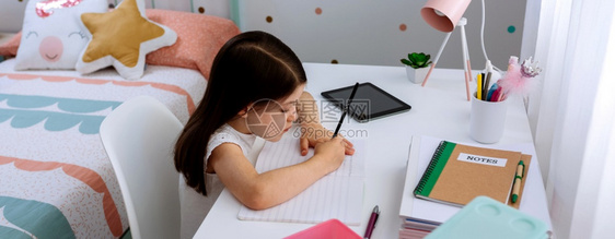 女孩在卧室做家庭作业图片