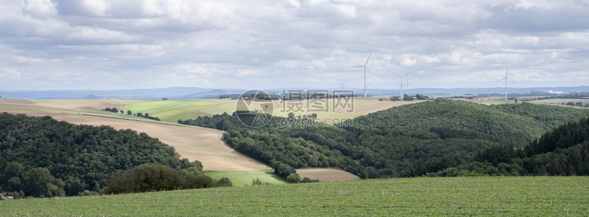 夏季在云层下的用德国叶子制造的田间涡轮机和圆形图片