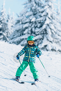 小男孩在阳光明媚的日子里滑雪图片