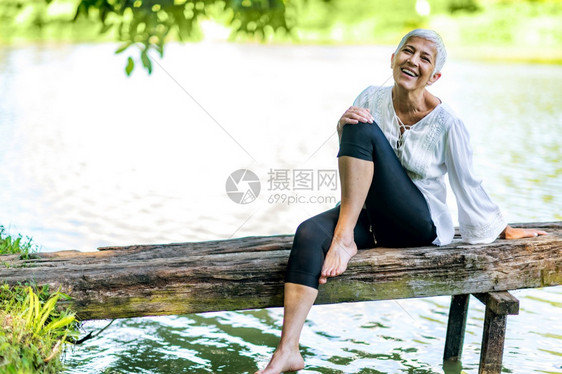 坐在水边享受大自然的安宁与和平享受大自然的安宁和美丽成年女子图片
