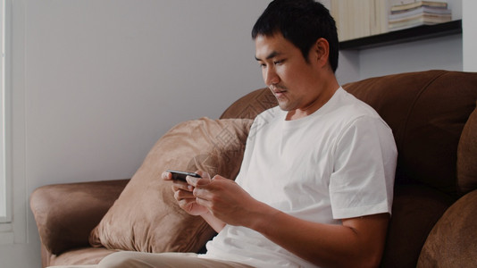 男在家沙发上休息感到快乐男人在家里玩游戏图片